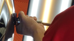 A person is using a screwdriver to open a door.