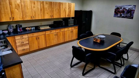 A kitchen with **black cabinets** and a table and chairs.
