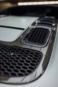A close up of a carbon fiber grille on a porsche 911.