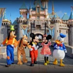 A group of disney characters standing in front of a castle.