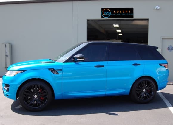 A blue range rover parked in front of a building.
