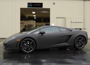A black lamborghini parked in front of a building.