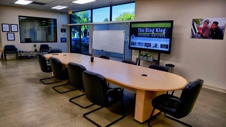 A conference room at a PDR training location with a large screen and chairs.