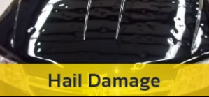 A black car with the words hail damage on the hood.