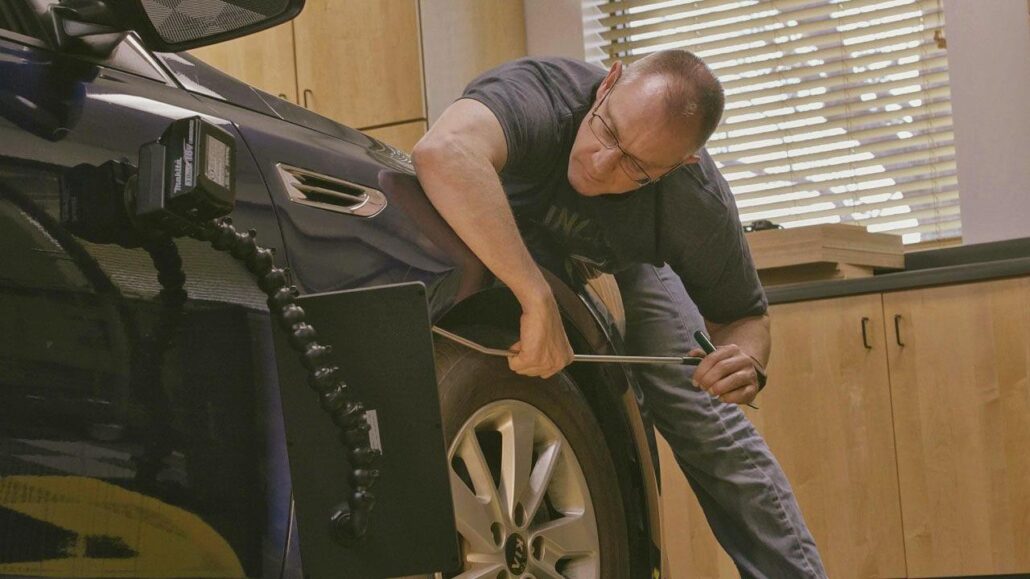 A man working on a tire in a garage.