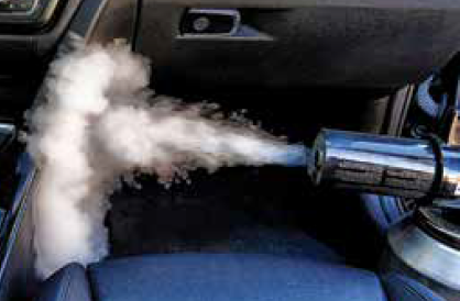 A car emitting white smoke undergoes odor removal.