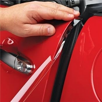 A hand demonstrating the removal of the chrome trim cover from a red car door handle using a thin black tool, while the car's windshield guard adds an extra touch of protection.