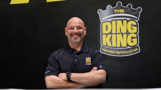 A man standing in front of the ding king sign.
